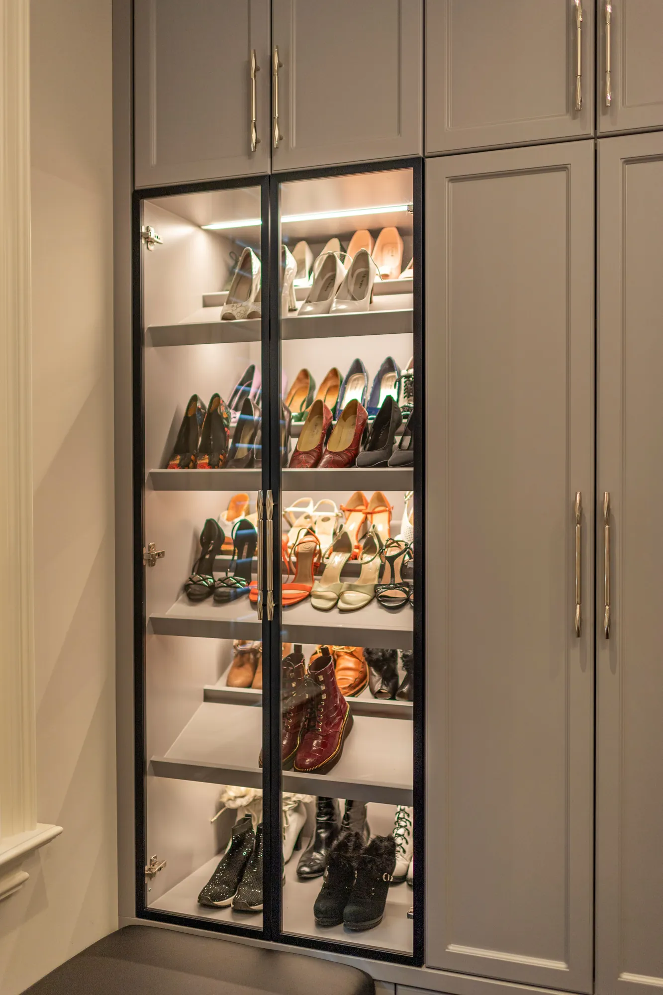 Lit shoe cabinet with dark-framed glass doors in Richmond Hill