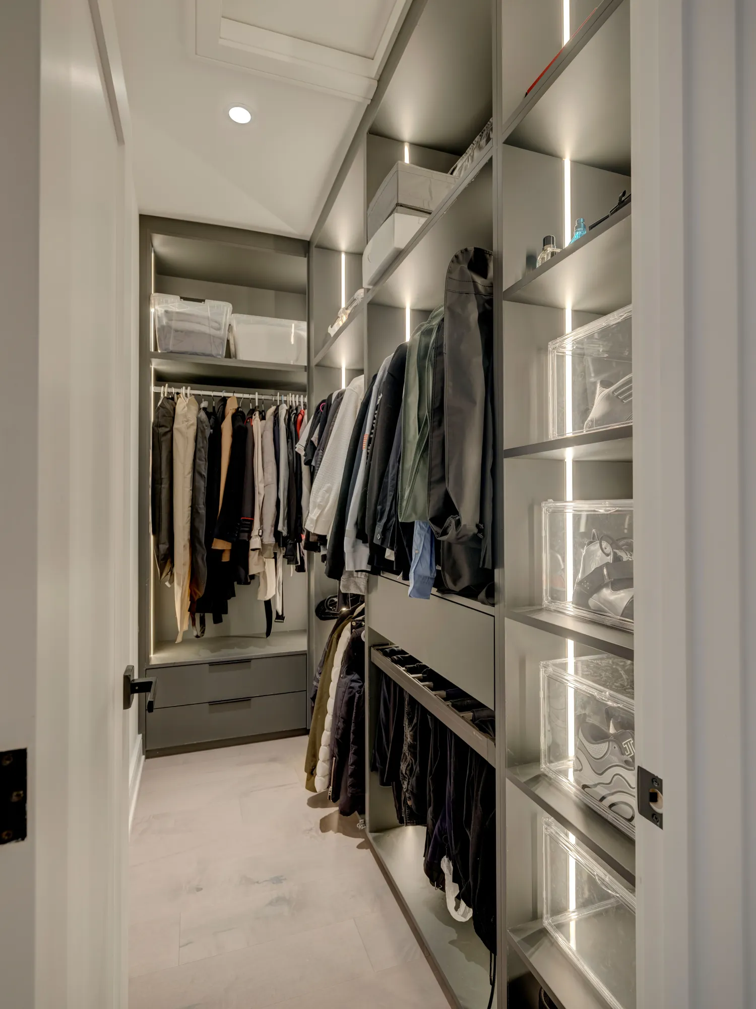 Narrow walk-in closet with lit uprights and two-level hanging in Richmond Hill