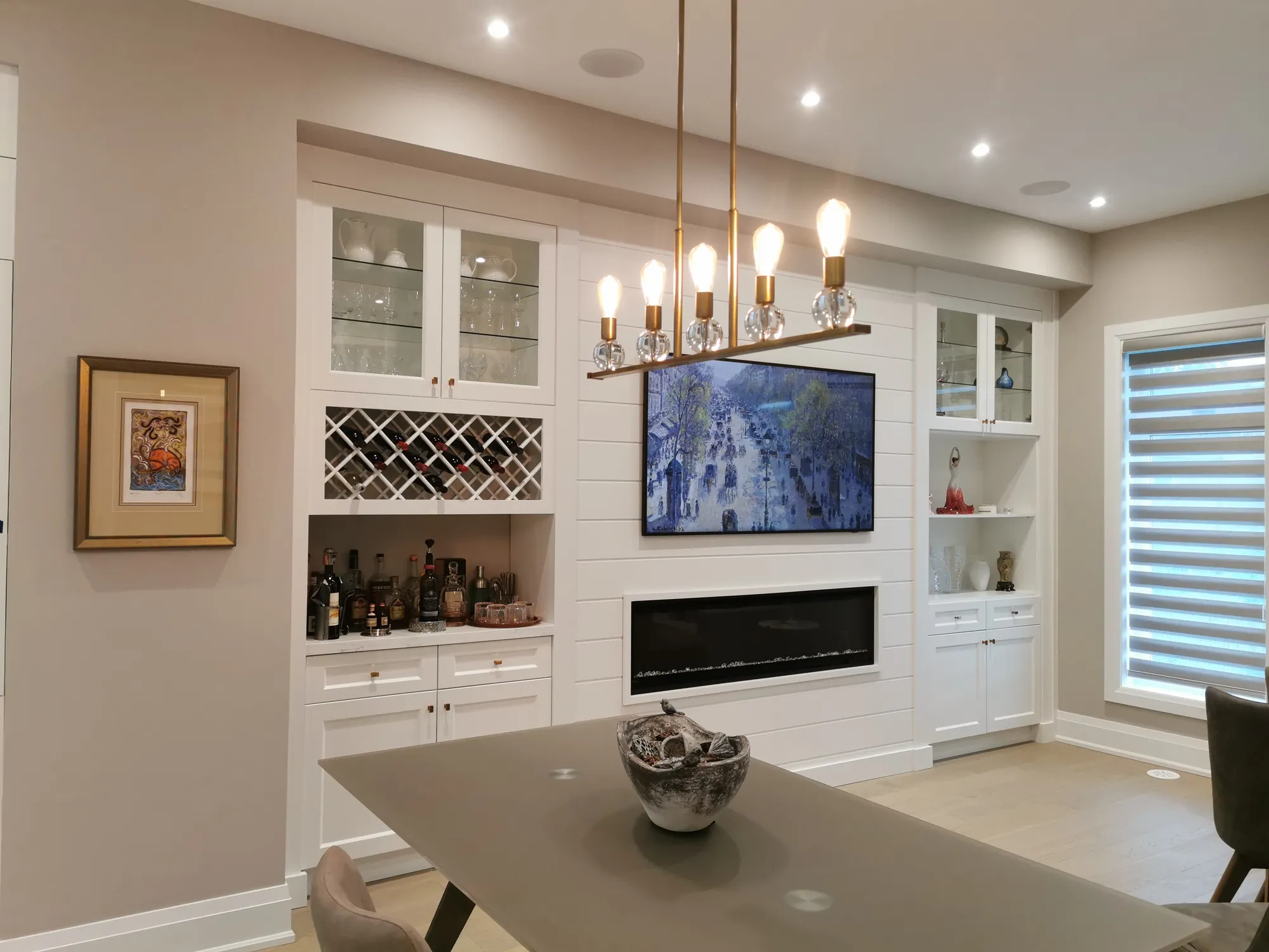 White built-in wall unit with television, linear fireplace, and wine rack in Thornhill